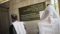 יהודים מתפללים מחוץ לכניסה להר הבית בסמוך לשלט האוסר על תפילה בו. (צילום ארכיון: יונתן זינדל/פלאש90)