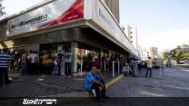 אזרחים ממתינים מחוץ לבנק הממשלתי כדי לקבל את שטרות הכסף החדשים שהשיקה הממשלה. 21 באוגוסט 2018 (AP Photo/Fernando Llano)