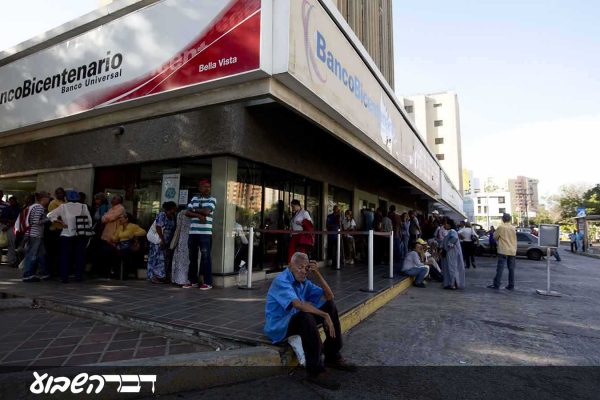 אזרחים ממתינים מחוץ לבנק הממשלתי כדי לקבל את שטרות הכסף החדשים שהשיקה הממשלה. 21 באוגוסט 2018 (AP Photo/Fernando Llano)