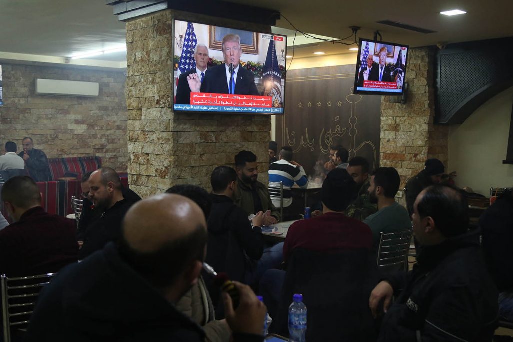 פלסטינים בבית קפה ברמאללה ברקע נאום טראמפ, 6 בדצמבר 2017 (צילום: פלאש 90).