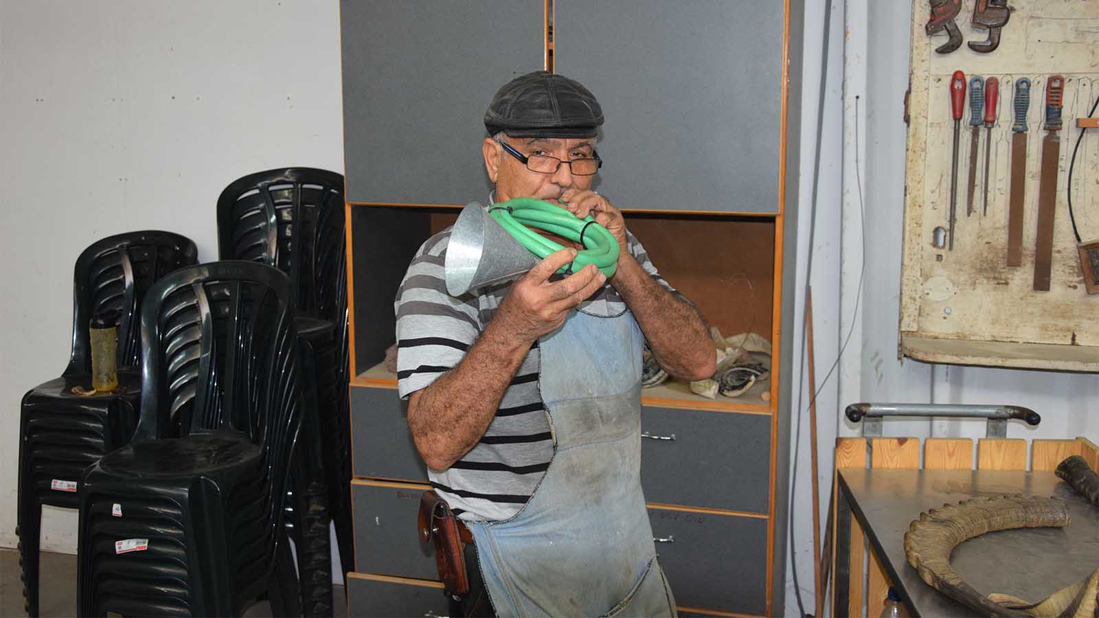 Shimon Keinan with a model of his first shofar made from hosepipe and a gasoline funnel. credit: Yael Elnatan