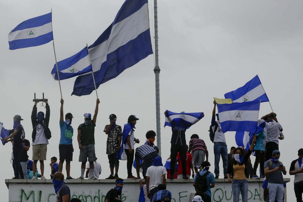 מפגינים מניפים את דגל ניקרגואה בקריאה להדיח את נשיא המדינה דניאל אורטגה ולשחרור האסירים הפוליטיים, 23 ביולי 2018. (צילום: AP Photo/Arnulfo Franco)