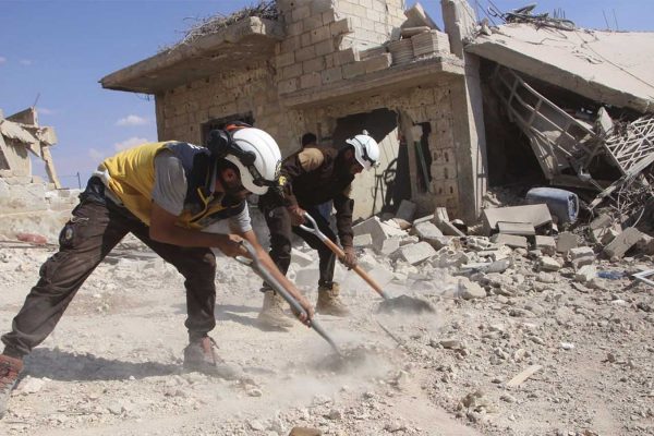 אנשי ארגון הסיוע האזרחי של סוריה (הקסדות הלבנות) מפנים הריסות בית שהופצץ על ידי חיל האוויר הסורי בכפר סמוך לאידליב, 10 בספטמבר 2018. (צילום: Syrian Civil Defense White Helmets via AP)
