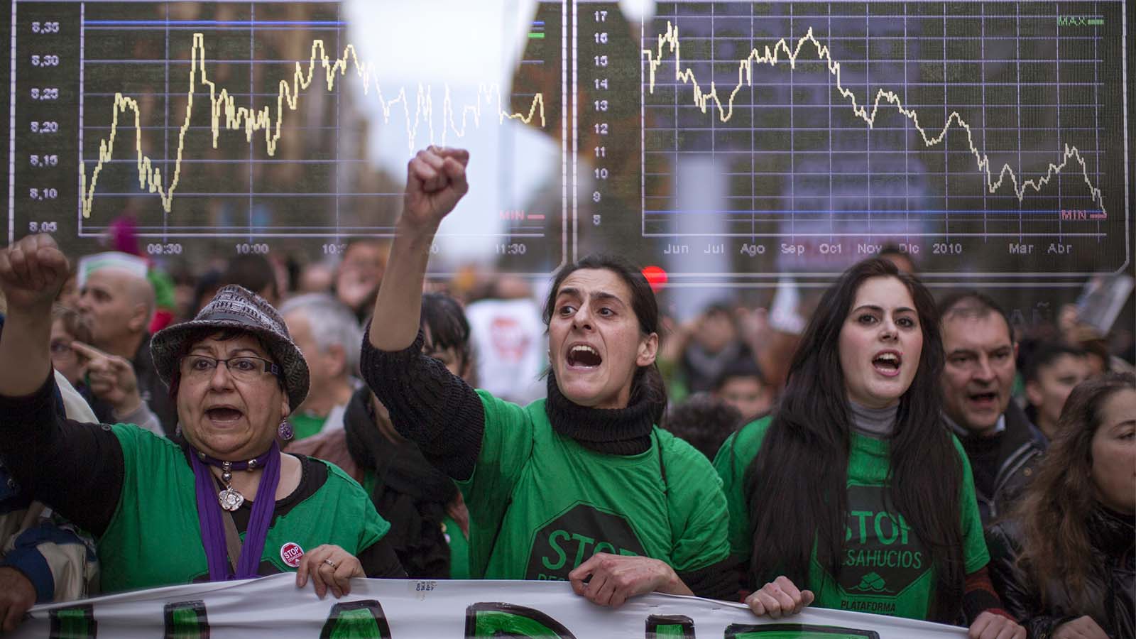 מחאה נגד פינויי בתים לצד מראה הגרפים בבורסת המניות בספרד לאחר משבר 2009 (צילום: AP photo).