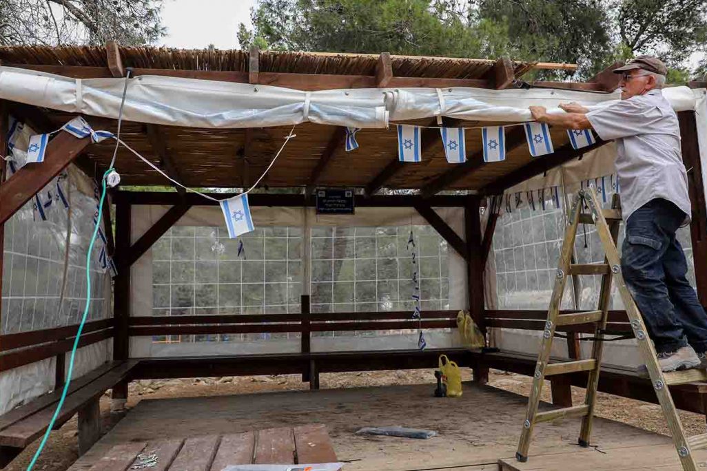 ישראלי בונה סוכה לקראת סוכות (צילום ארכיון: גרשון אלינסון/ פלאש90)