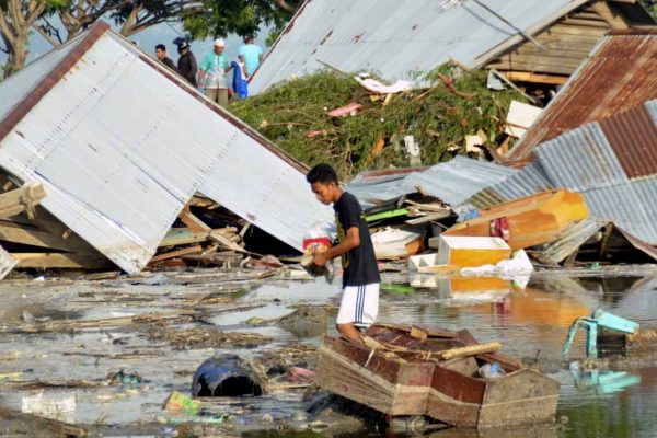 אדם בהריסות ביתו כתוצאה מרעידת אדמה וצונאמי בפאלו, אינדונזיה. 29 בספטמבר 2018. (AP Photo/Rifki)