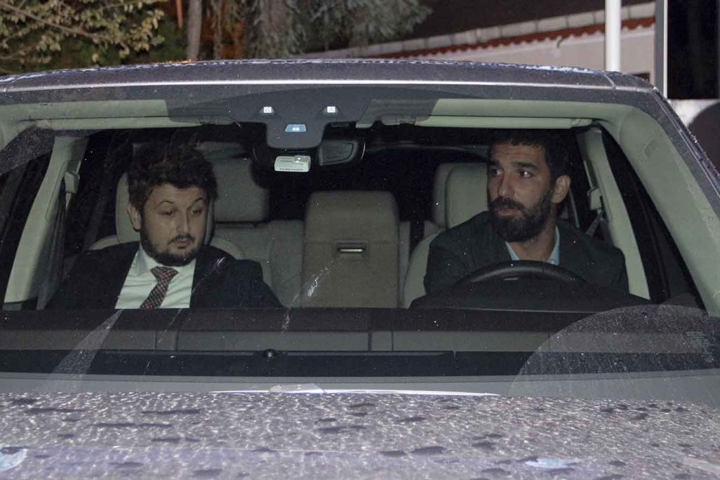 Barcelona's Turkish player Arda Turan, right, leaves a police station in Istanbul, Thursday, Oct. 11, 2018. Turan has given testimony to police following a nightclub brawl during which he reportedly broke the nose of a singer.  The DHA news agency said Turan, who is on loan to Istanbul side Basaksehir, was called to a police station where he was questioned for three hours on Thursday. (IHA via AP)