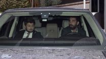 Barcelona's Turkish player Arda Turan, right, leaves a police station in Istanbul, Thursday, Oct. 11, 2018. Turan has given testimony to police following a nightclub brawl during which he reportedly broke the nose of a singer.  The DHA news agency said Turan, who is on loan to Istanbul side Basaksehir, was called to a police station where he was questioned for three hours on Thursday. (IHA via AP)