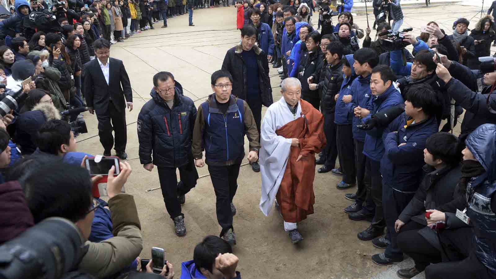האן סאנג ג'ונג, הנשיא לשעבר של קונפדרציית האיגודים המקצועיים של קוריאה KCTU מסגיר את עצמו למשטרה, לאחר שהתבצר במנזר בסיאול עם תומכיו. 10 בדצמבר 2015 (Choi Dong-jun/Newsis via AP)