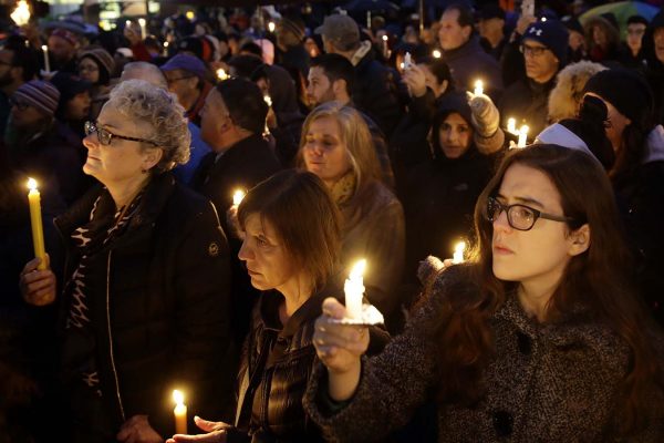 חברות וחברי הקהילה היהודית מדליקים נרות בסמוך למקום אירוע הירי בבית הכנסת "עץ חיים" בפיטסבורג, שבת, 27 באוקטובר 2018 (AP Photo/Matt Rourke)