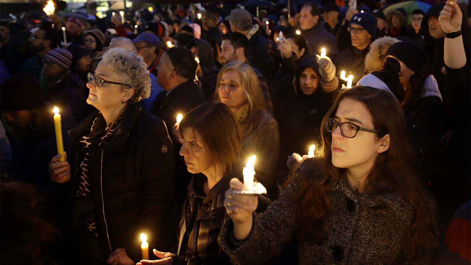חברות וחברי הקהילה היהודית מדליקים נרות בסמוך למקום אירוע הירי בבית הכנסת &quot;עץ חיים&quot; בפיטסבורג, שבת, 27 באוקטובר 2018 (AP Photo/Matt Rourke)