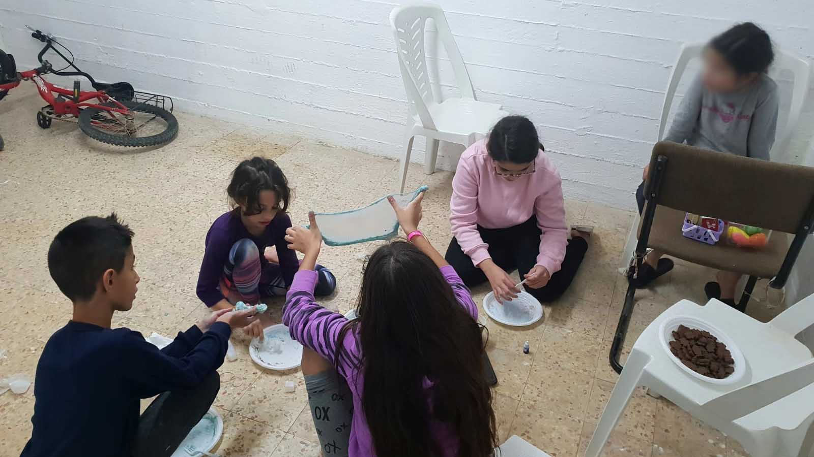 Children making &quot;slime&quot; in a bomb shelter in Ofakim. Archive. Nov. 12, 2018. (Nofar Zohar)