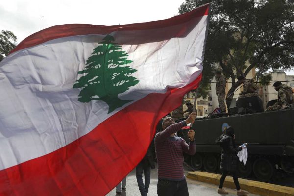 מפגין מניף את דגל לבנון בהפגנה נגד השחיתות ואוזלת היד של הפוליטיקאים. 22 בנובמבר 20148 (AP Photo/Hussein Malla)