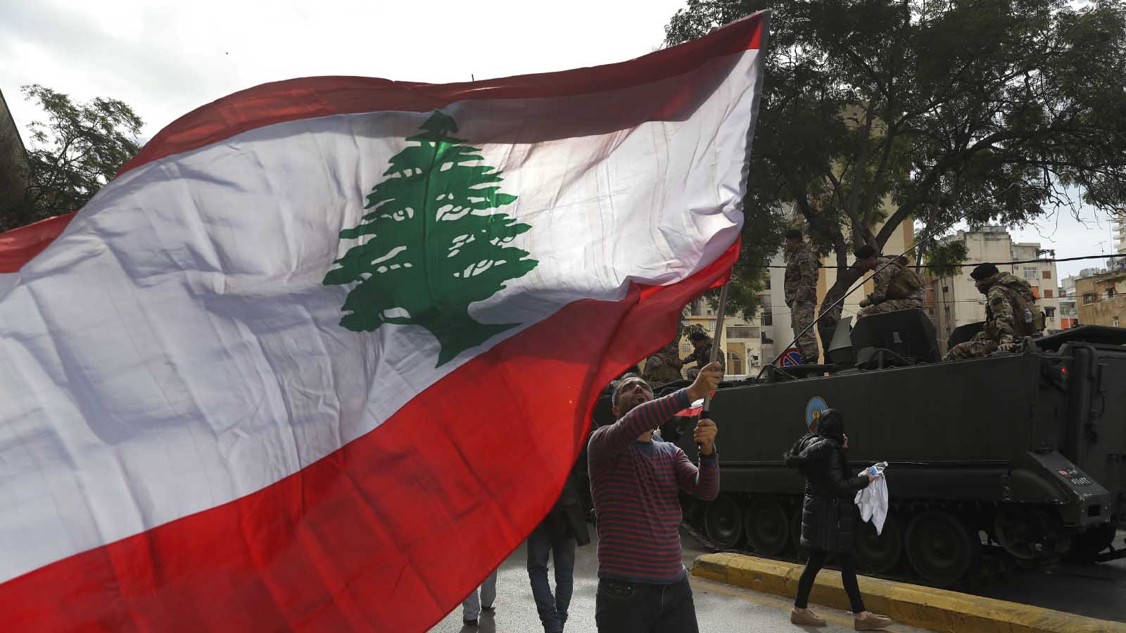 מפגין מניף את דגל לבנון בהפגנה נגד השחיתות ואוזלת היד של הפוליטיקאים. 22 בנובמבר 20148 (AP Photo/Hussein Malla)