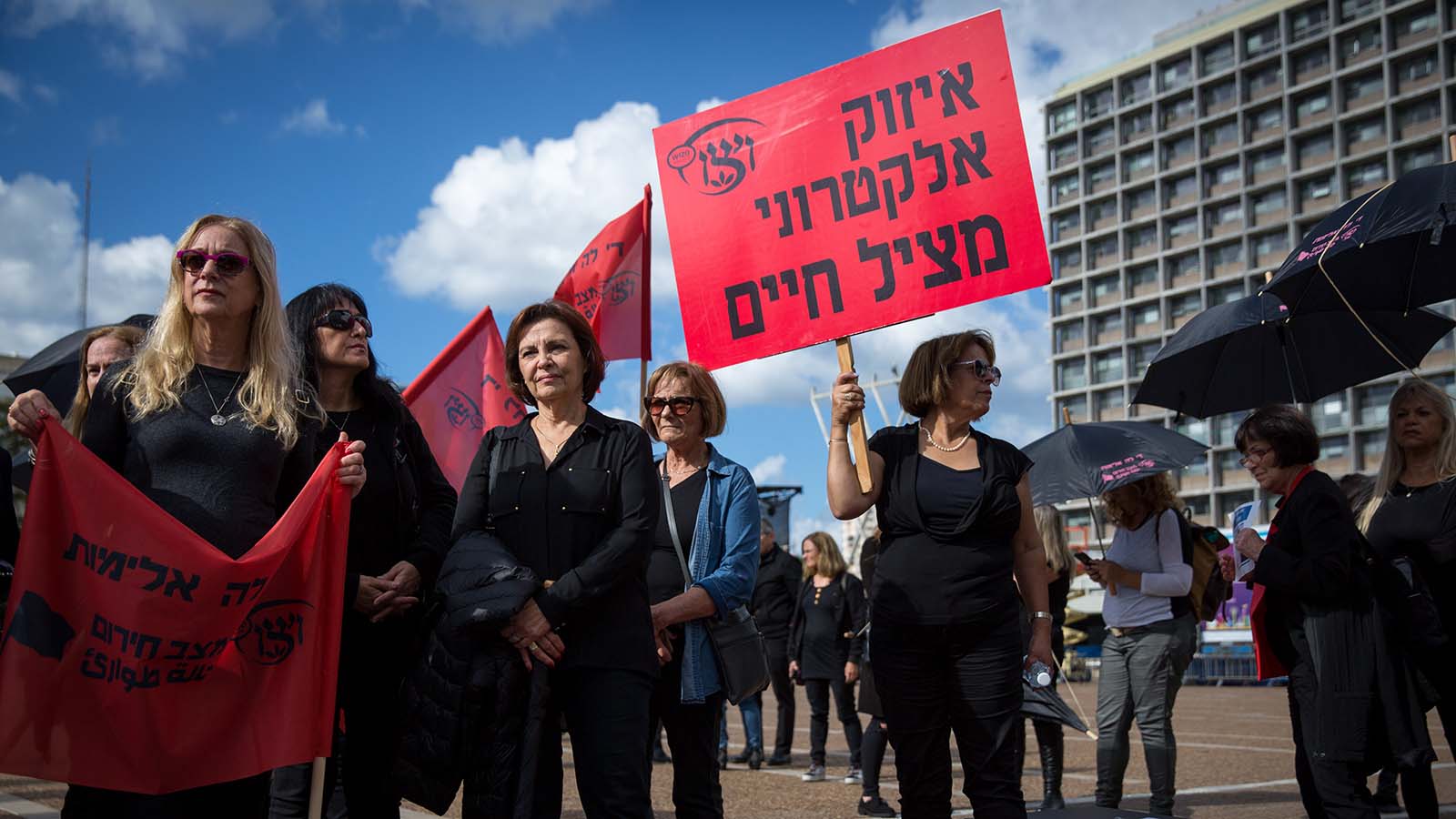 שלט הקורא לאכיפת איזיקים אלקרטוניים במחאת הנשים בתל אביב. 4 בדצמבר 2018 (מרים אלסטר/פלאש90)