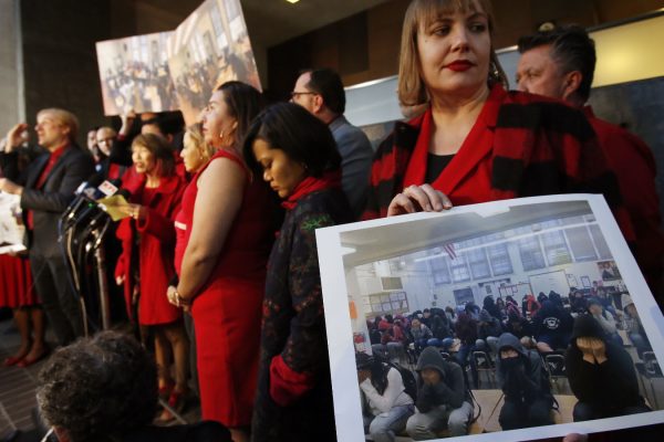 מורה באיגוד המורים של לוס אנלג'ס מחזיקה תמונה של כיתה עם 39 ילדים בסיבת עיתונים במחאה על העומס בכיתות בלוס אנג'לס. 11 בינואר 2019 (AP Photo/Damian Dovarganes)