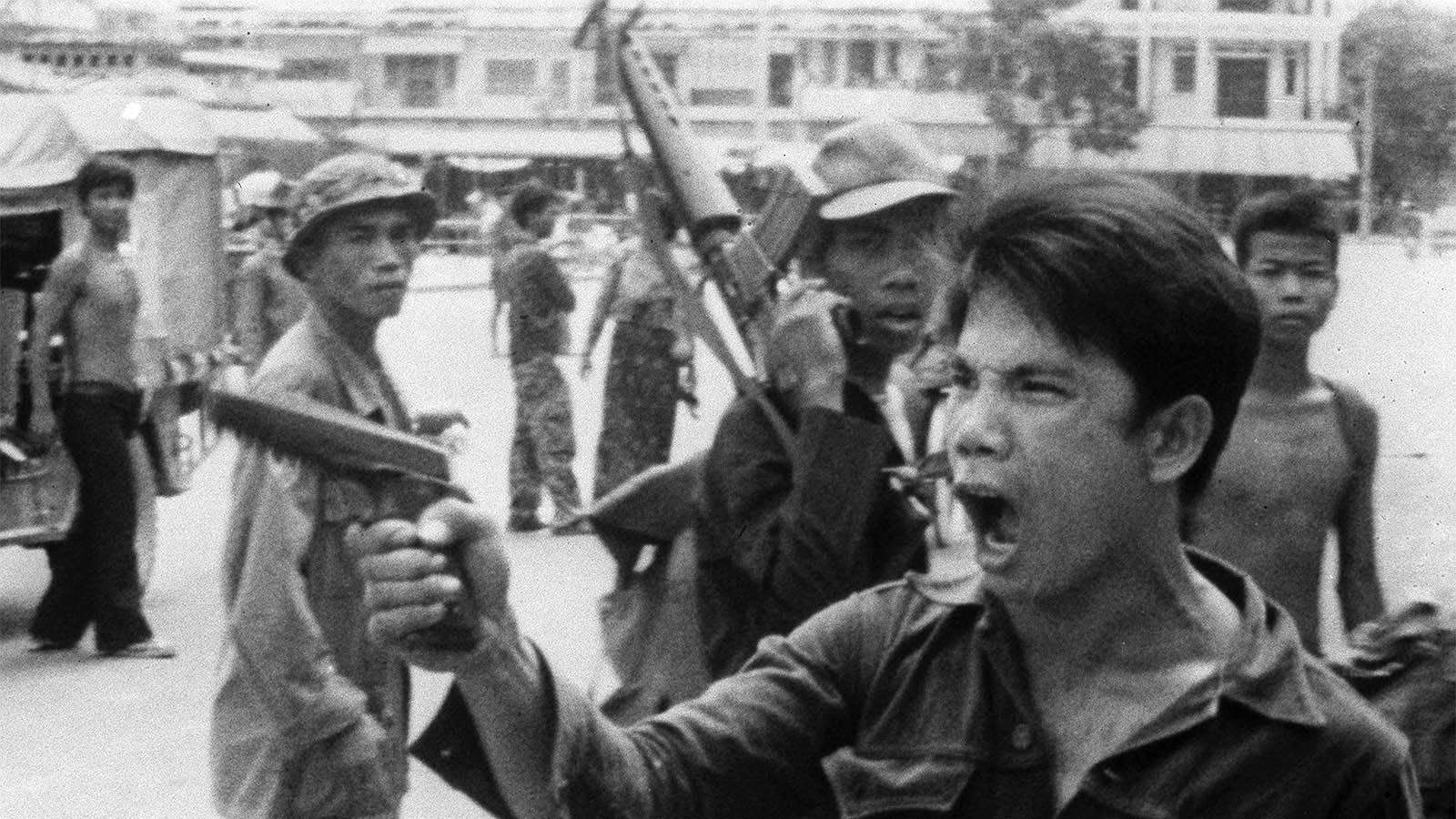 חייל מתנועת הקמר רוז' מאיים על בעל חנות בפנום פן, בירת קמבודיה. אפריל 1975 (AP Photo/Christoph Froehder, File)