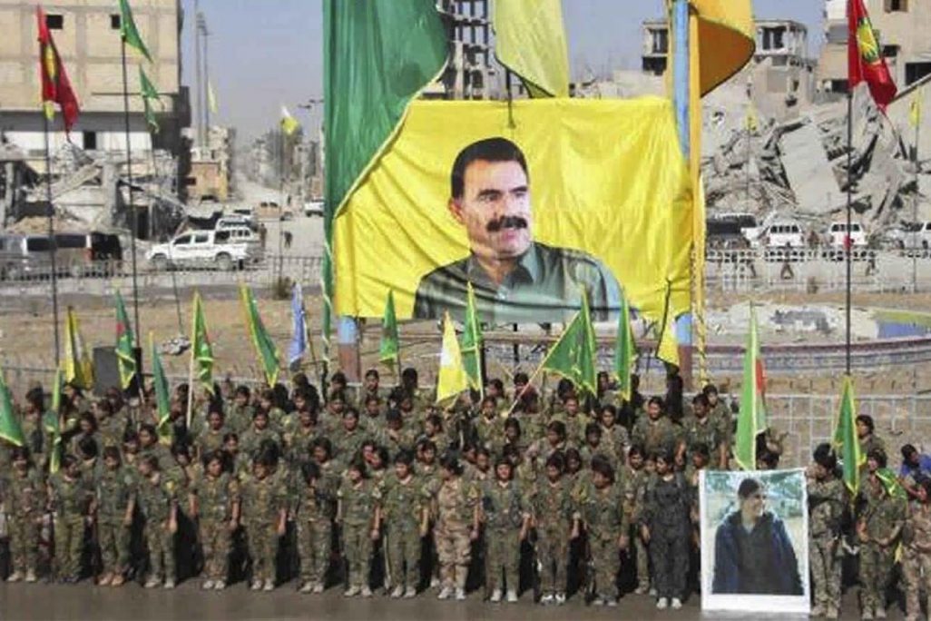 תמונותו של עבדאללה אוג'לאן מנהיג ה-PKK במסדר צבאי של לוחמות כורדיות לאחר שניצחו את דאע"ש בא-ראקה, סוריה. 19 באוקטובר 2017 (Ronahi TV, via AP) תמונותו של עבדאללה אוג'לאן מנהיג ה-PKK במסדר צבאי של לוחמות כורדיות לאחר שניצחו את דאע"ש בא-ראקה, סוריה. 19 באוקטובר 2017 (Ronahi TV, via AP)