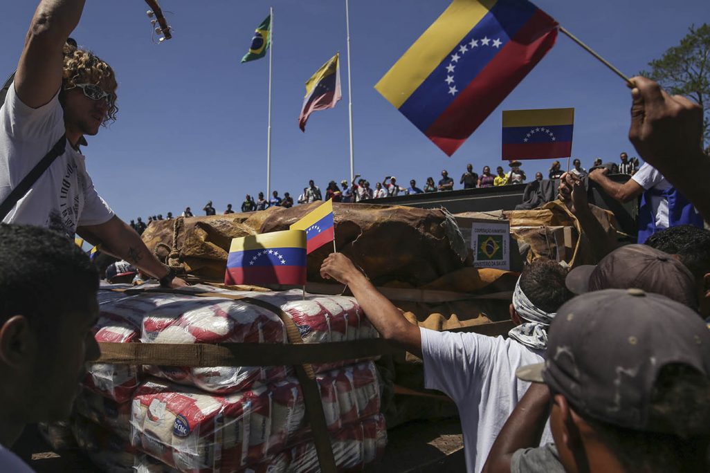 אנשים בונצואלה מתגודדים סביב אספקת ציוד הומניטרי ממשלת ברזיל שהגיע דרך הגבול. 23 בפברואר 2019 (AP Photo/Ivan Valencia)