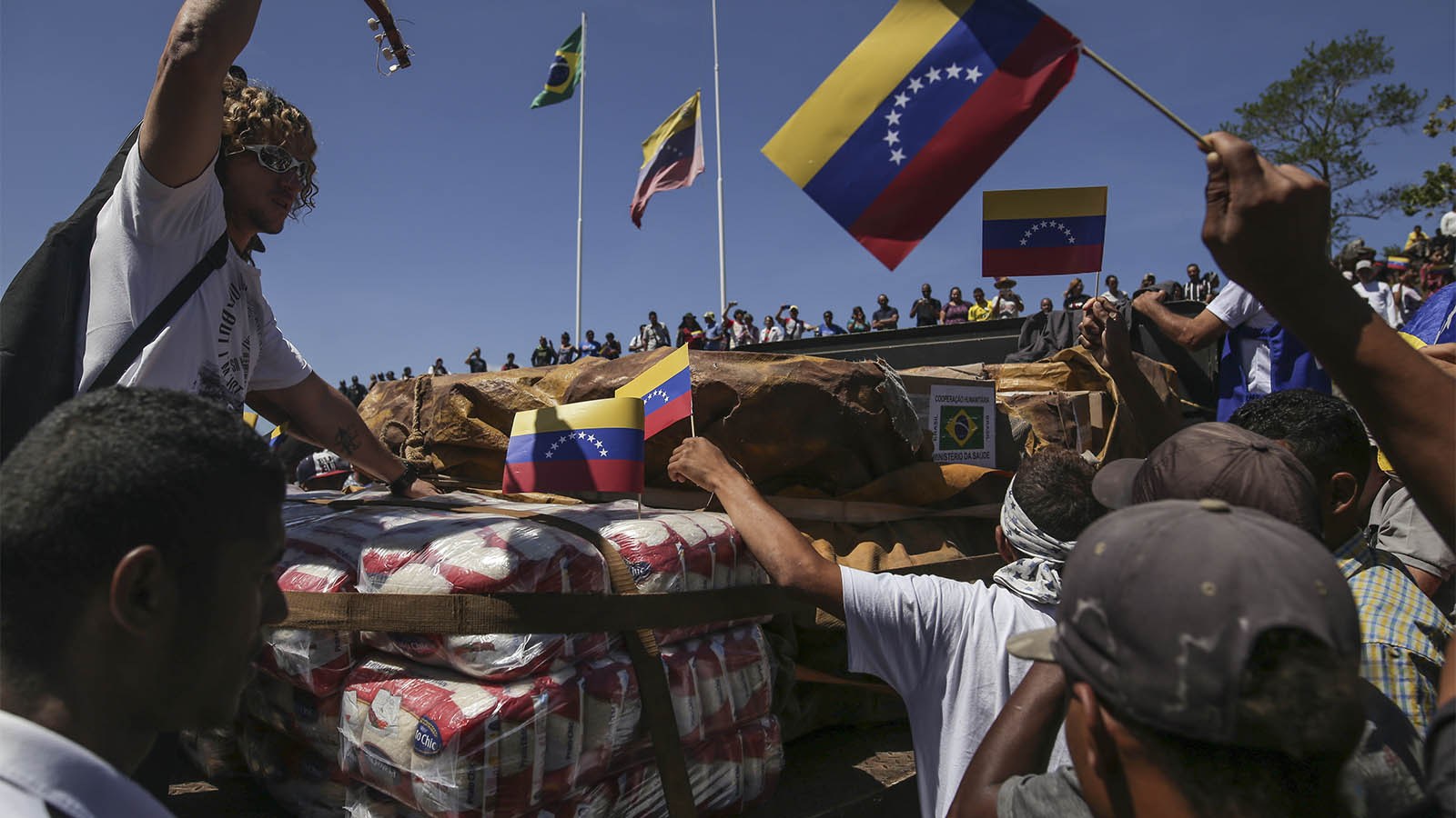 אנשים בונצואלה מתגודדים סביב אספקת ציוד הומניטרי ממשלת ברזיל שהגיע דרך הגבול. 23 בפברואר 2019 (AP Photo/Ivan Valencia)
