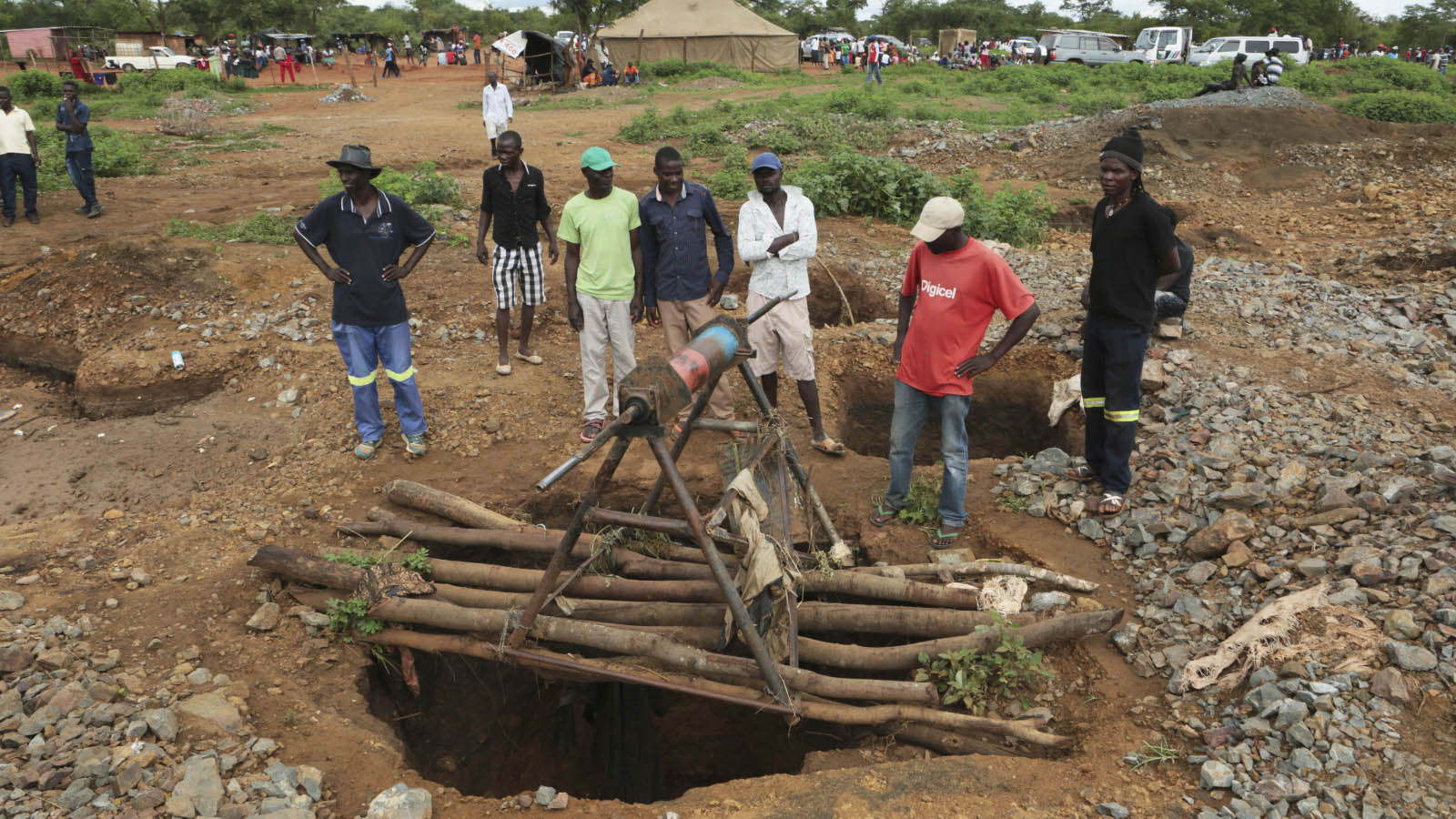 מחלצים עומדים מעל כניסה למכרה שהוצף בזימבבואה, בנסיון להציל כורים לכודים(AP Photo/Tsvangirayi Mukwazhi)