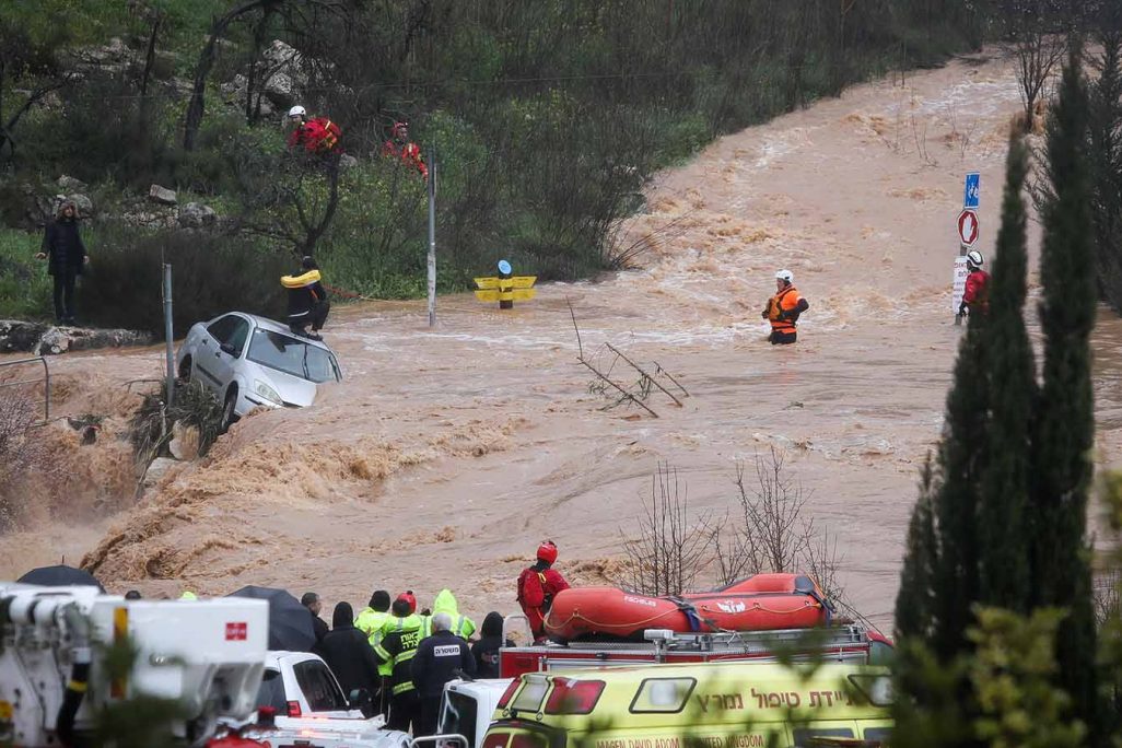 חילוץ אדם הלכוד מעל רכבו בעמק הארזים בשל השיטפונות. (נועם רבקין פנטון/פלאש90)