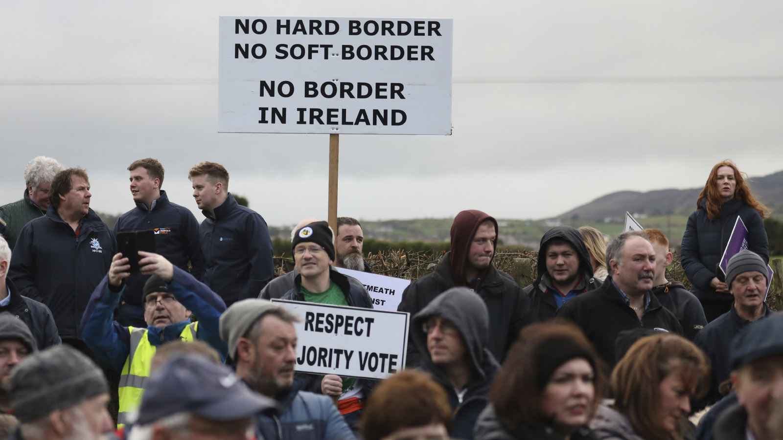 מפגינים נושאים שלטים הדורשים המשך של המצב הקיים היום בו אין גבול ממשי בין המדינות. נוארי, בגבול בין צפון אירלנד לרפובליקה של אירלנד, 26 לינואר 2019 . (AP Photo/Peter Morrison)