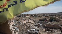 דגל של הכוחות הסוריים הדמוקרטיים מתנוסס מעל מעוז נטוש של דאע"ש, אחרי תבוסת הארגון בסוריה. (צילום: by Chris McGrath/Getty Images)