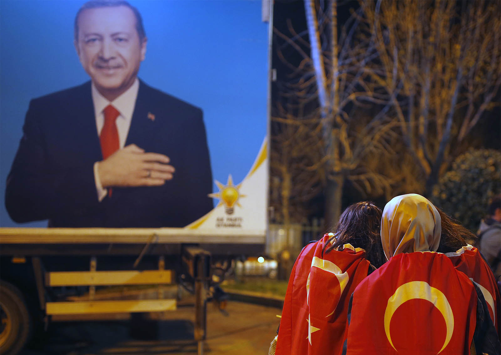 תומכות ארדואן עטופים בדגל טורקיה בבחירות באיסטנבול (AP Photo/Emrah Gurel)