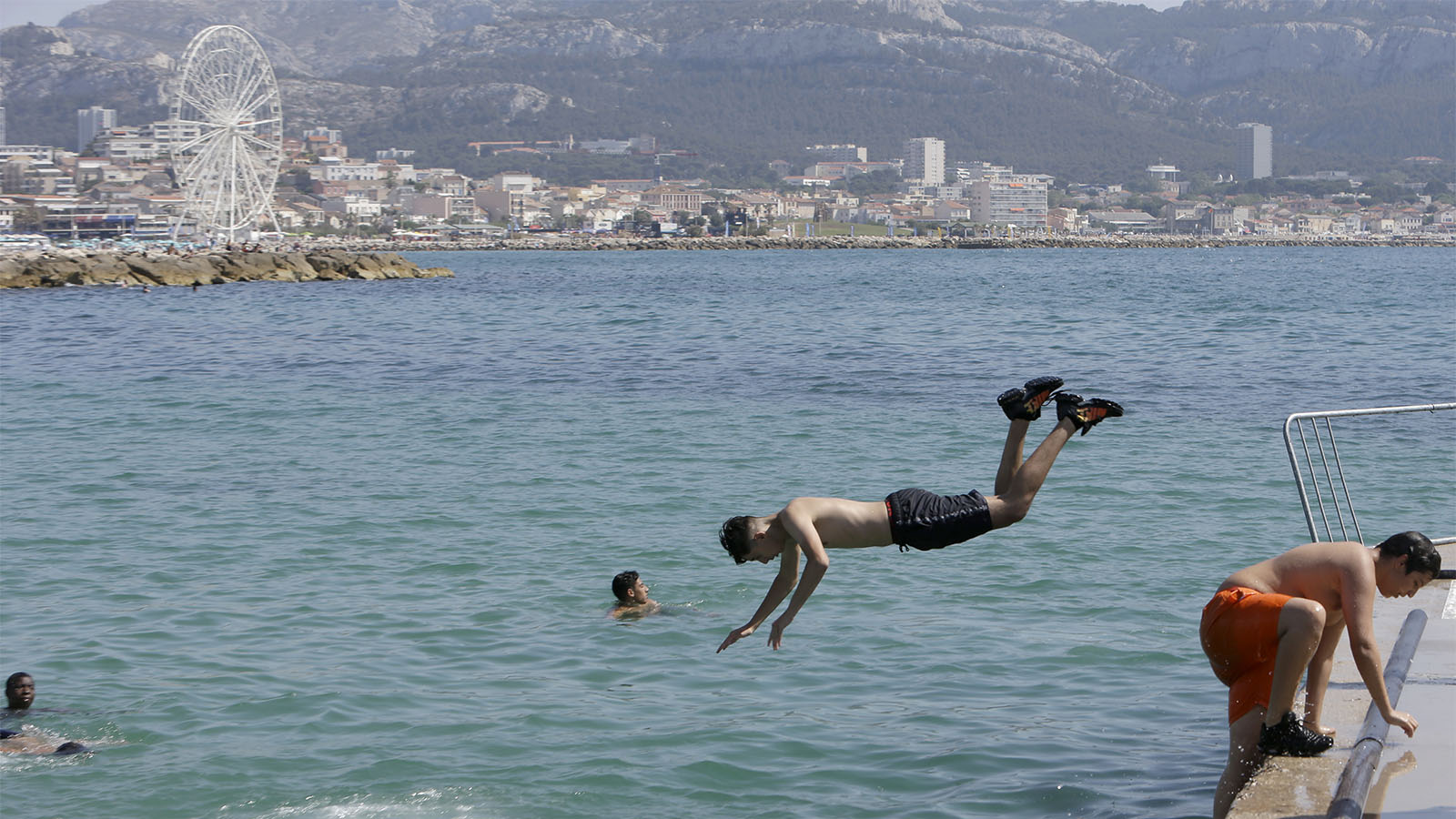 ילדים צוללים למי הים התיכון במרסיי במהלך גל החום הקיצוני באירופה, יוני 2019 (AP Photo/Claude Paris)