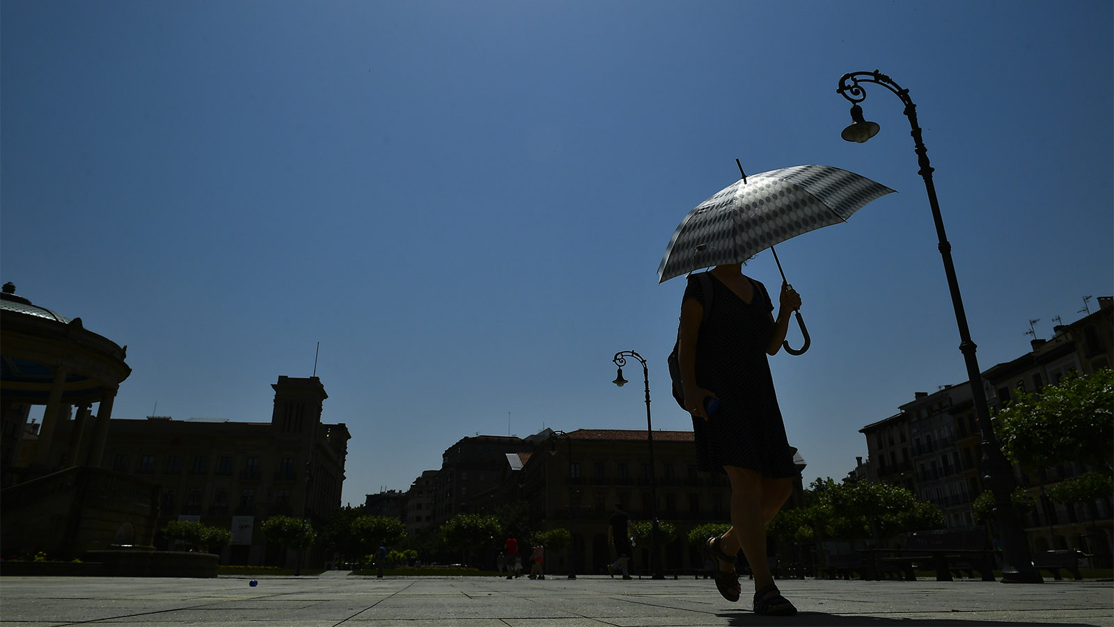 אישה מתגוננת בפניה השמש בספרד במהלך גל חום קיצוני באירופה (AP Photo/Alvaro Barrientos)