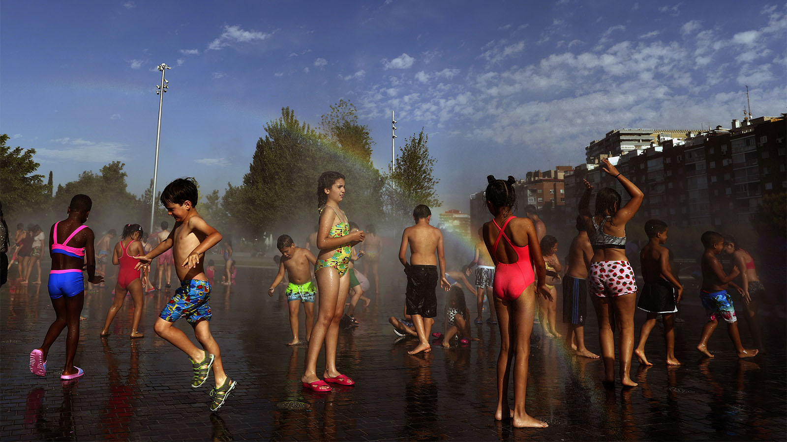 ילדים מבלים במזרקה בפארק במדריד במהלך גל חום קיצוני באירופה, יוני 2019 (AP Photo/Manu Fernandez)