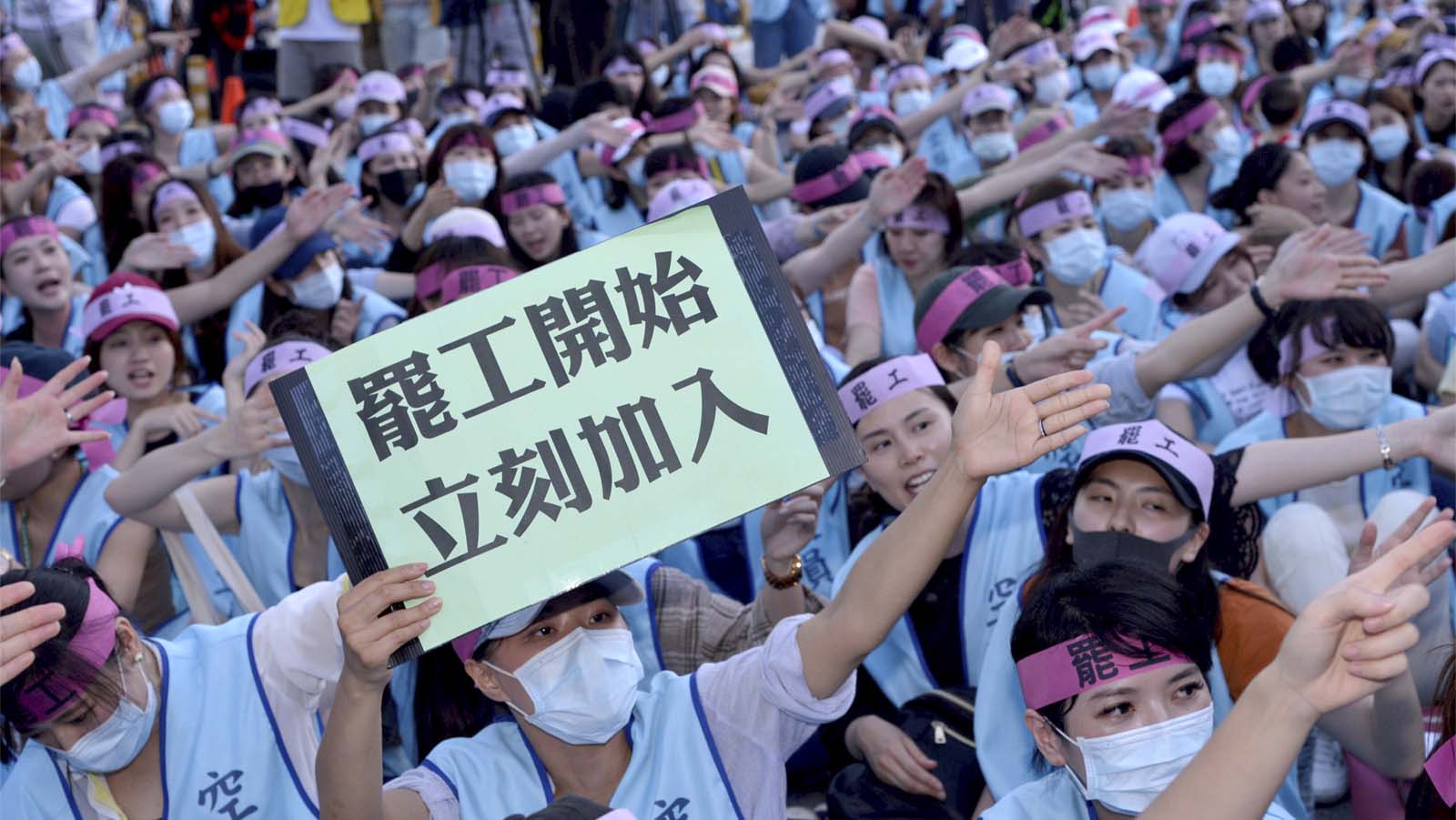 דיילת באווה אייר מחזיקה שלט עליו כתוב &quot;השבית החלה, הצטרפו מייד&quot;, במהלך הפגנה מול מטה החברה בטאיוואן. (AP Photo)