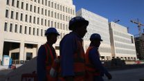עובדי בניין יוצאים מאתר בנייה בדוחא קטאר. אפריל 2019 (AP Photo/Kamran Jebreili)
