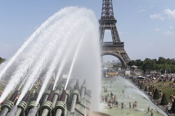 זרנוקי מים מקררים תיירים ואזרחים בבירכה סמוך למגדל אייפל, פריז צרפת בשל גל החום. 25 ביולי 2019 (Photo by Samuel Boivin/NurPhoto via Getty Images)