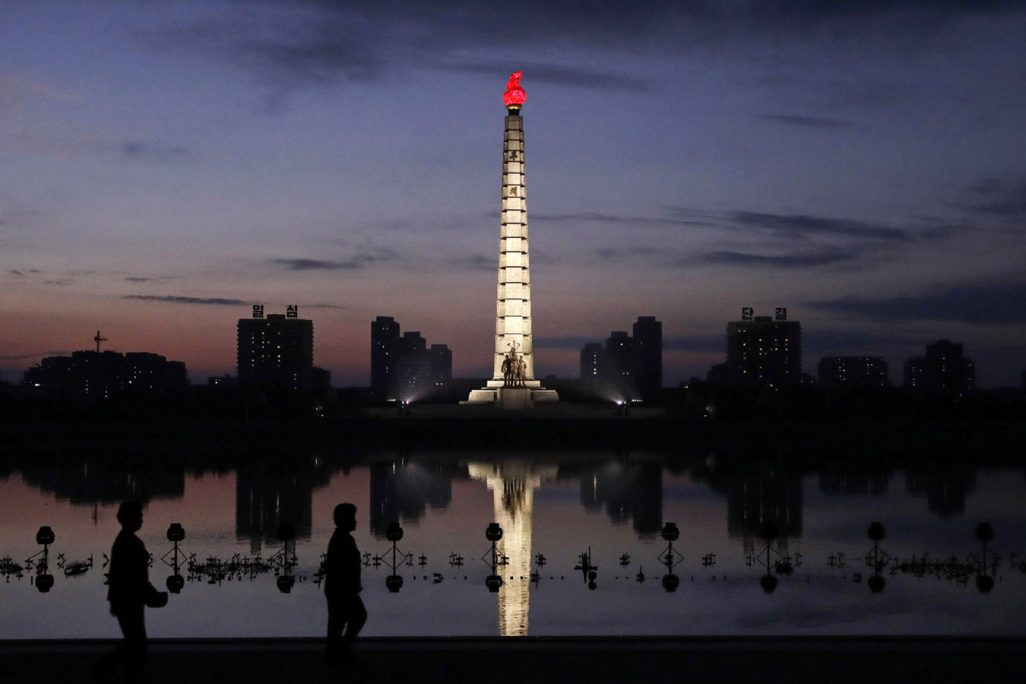 צפון קוריאנים מטיילים בזריחה למרגלות מגדל אידאולוגיית הג'וצ'ה בפיונגיאנג. (צילום: AP Photo/Kin Cheung)