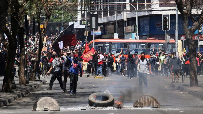 מפגינים מתעמתים עם כוחות משטרה במהלך מחאות ברחבי צ'ילה. 21 באוקטובר 2019 (Photo by Marcelo Benitez/Getty Images)