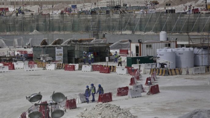 عمال في موقع بناء استاد كأس العالم لكرة القدم في قطر (تصوير: وكالة AP).