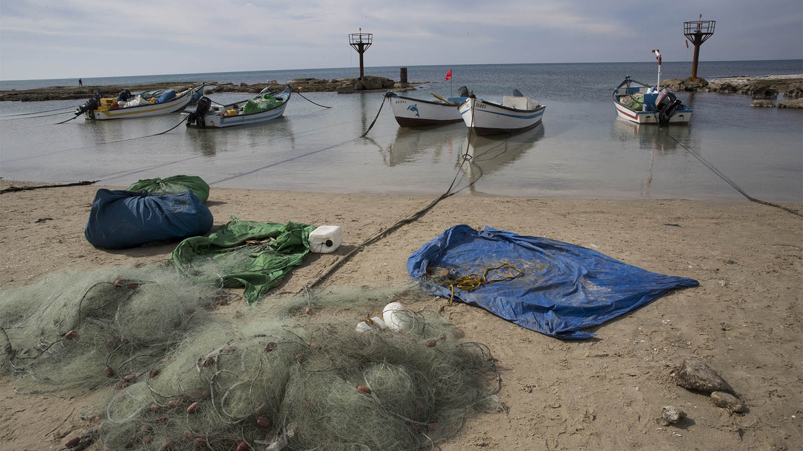 Fishing boats and fishing nets on the beach in the Israeli Arab town of Jisr az-Zarqa, on February 4, 2017. Photograph by Nati Shohat/Flash90
