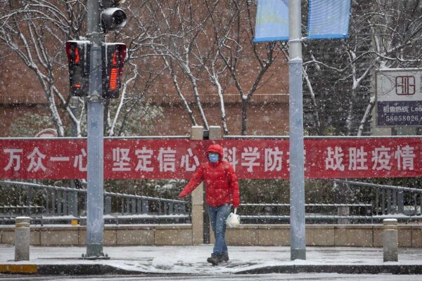 הולך רגל עומד לבדו ברחוב בבייג'ין, 2 פברואר 2020 (צילום: AP Photo/Mark Schiefelbein).