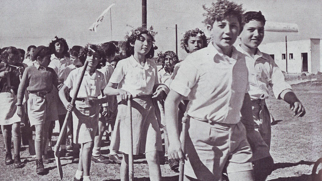 Children holding shovels marching to plant trees on Tu B'shvat. Photograph: La'am