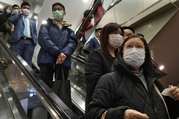 בשל נגיף הקורונה, אנשים עם מסיכות מגן בקניון בהונג-קונג (AP Photo/Vincent Yu)