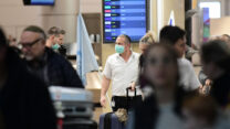 אנשים עוטים מסכות פנים בנתב"ג (צילום: תומר נויברג/פלאש90)