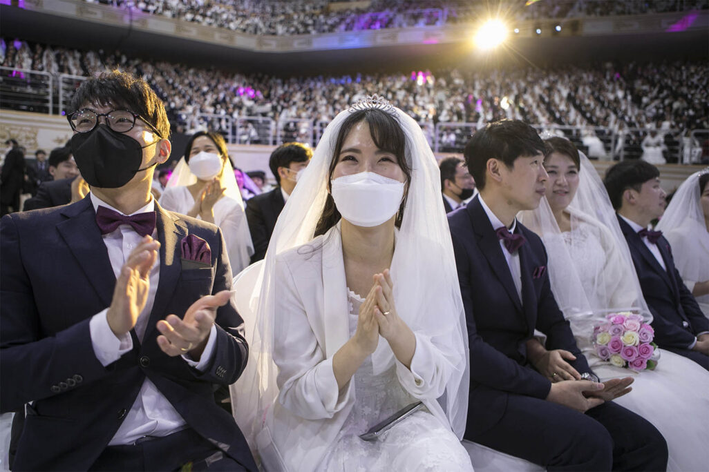 כלה וחתן עם מסכות נגד קורונה בחתונה המונית בקוריאה הדרומית. (Photo by Woohae Cho/Getty Images)