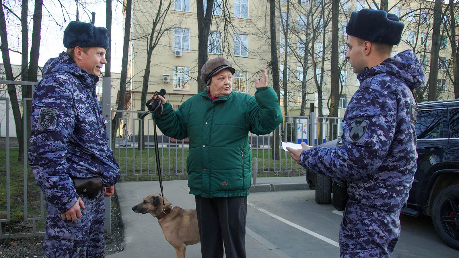 אנשי המשמר האזרחי מדברים עם אזרחית ותיקה בפארק במוסקבה על הוראות לסגר לאזרחים ותיקים ובעלי מחלות רקע. 25 במרץ (AP Photo/Aleksandr Avilov)