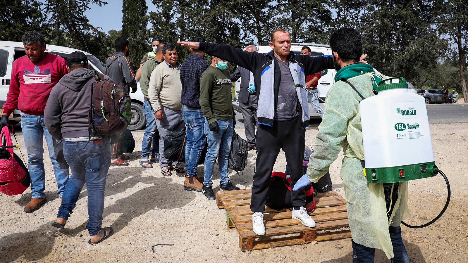 عمال فلسطينيون معقمون عند عودتهم الى السلطة الفلسطينية من إسرائيل. 27 من آذار. (تصوير: وسام هشلمون / فلاش 90)