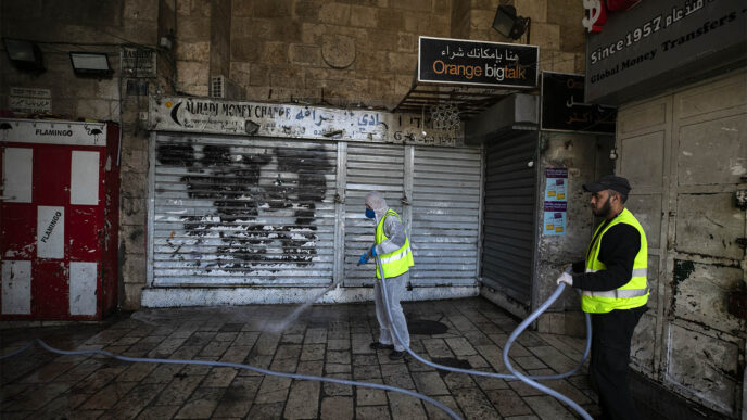 עובדי עיריית ירושלים מחטאים נגד נגיף הקורונה בעיר העתיקה. 29 במרץ 2020 (צילום: אוליבר פיטוסי/פלאש90)