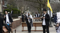 חסידי חב"ד בברוקלין ניו יורק מתפללים בריחוק חברתי 20 במרץ (AP Photo/Mark Lennihan)