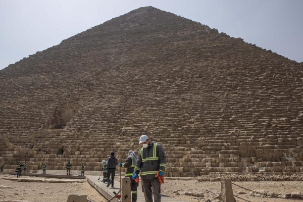 עובדי עירייה מחטאים סביב הפירמידות בגיזה שבמצרים במטרה לבלום את התפשטות נגיף הקורונה. 25 במרץ 2020 (AP Photo/Nariman El-Mofty)