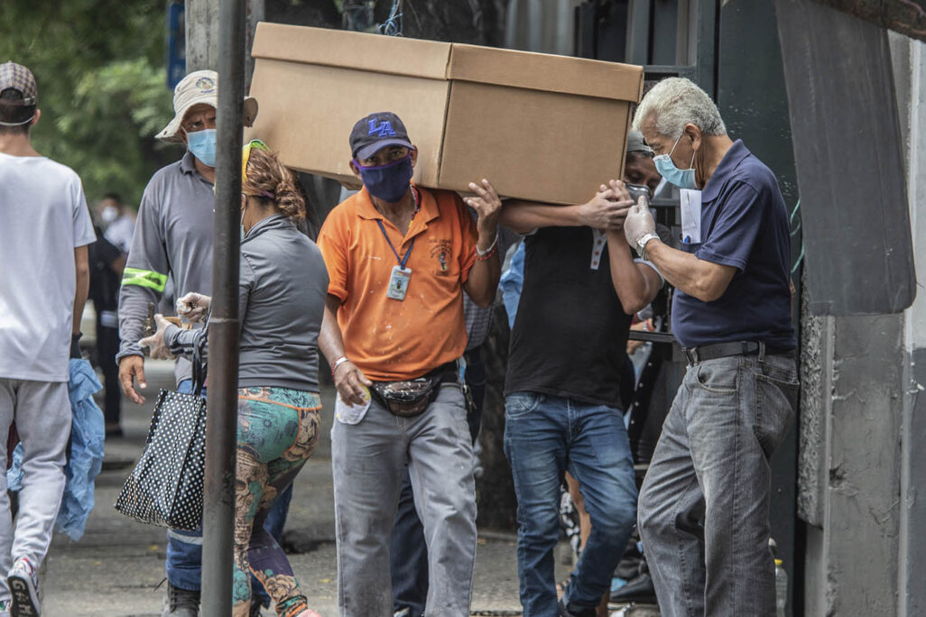אנשים סוחבים ארון קבורה מקרטון בדרך לבית העלמין בעיר גוויאקיל, אקוודור. 6 באפריל 2020.  (AP Photo/Luis Perez)